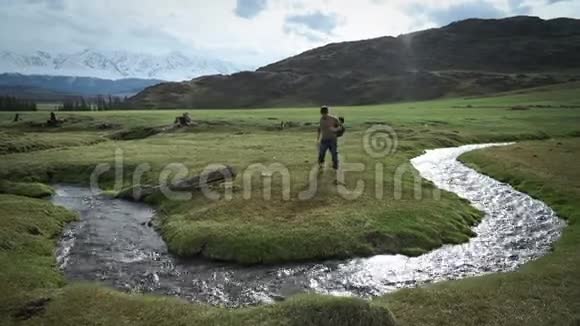 背包客HikerMan来到山溪把一些水抽到烧瓶里视频的预览图