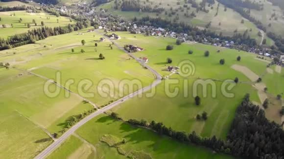 空中无人机镜头田野之间的道路在群山的背景下视频的预览图