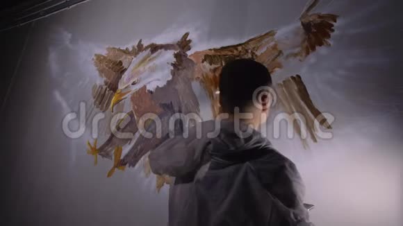 艺术家设计师在墙上画一只鹰工匠装饰师用丙烯酸油彩画一幅画视频的预览图