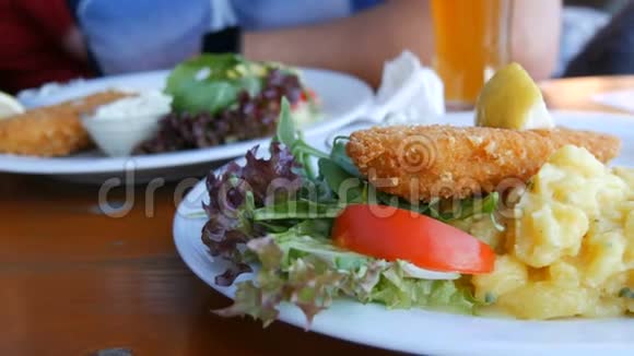 在一家昂贵的餐馆里在白色盘子上的面糊里放两份煮熟的漂亮鱼巴伐利亚州附近视频的预览图