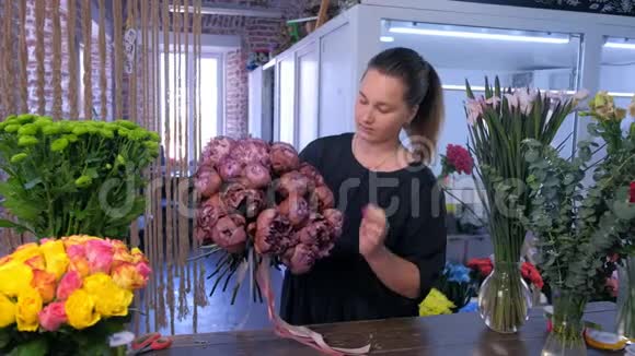 花商女作在花店做一束棕色栗色牡丹视频的预览图
