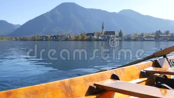一幅宁静的画一艘木船船上有桨漂浮在美丽的提格尔尼湖上以高山为背景视频的预览图