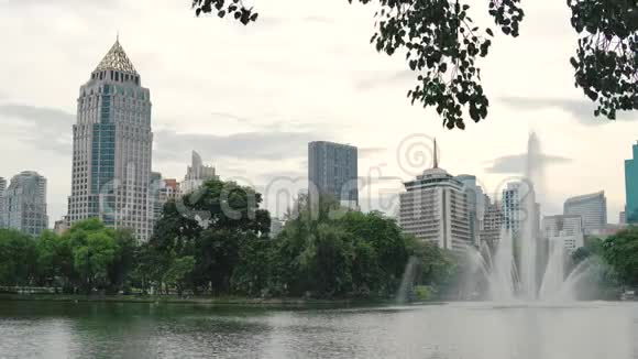 美丽的高喷泉在湖面上的城市公园市中心的建筑背景喷泉喷溅下来视频的预览图