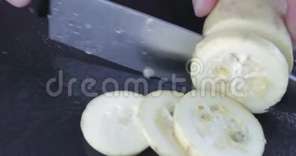 厨师用刀子把西葫芦切在黑桌上视频的预览图