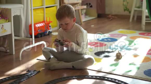 家庭生活方式一个小男孩在孩子们房间里玩玩具火车视频的预览图