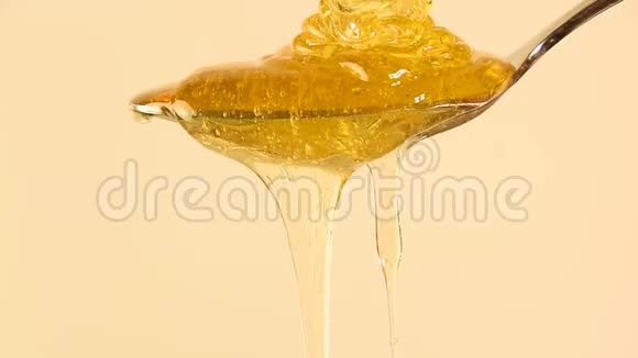 把蜂蜜从米色的金属勺子里流出来视频的预览图