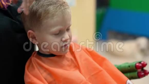 一个小男孩在儿童美发沙龙理发视频的预览图