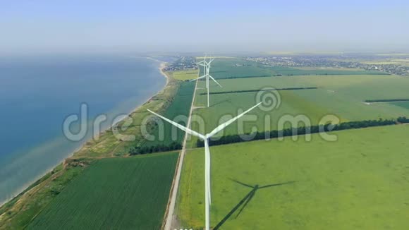 替代能源风电场在沿着海岸的绿色田野上视频的预览图