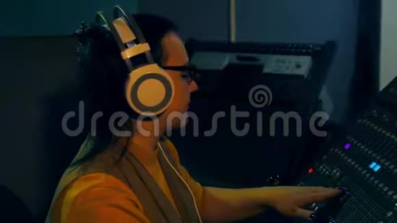 女士DJ在耳机和眼镜混合轨道迪斯科混合控制台视频的预览图