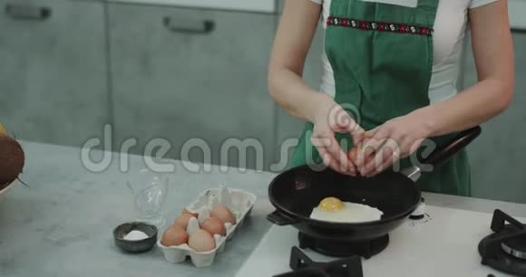 一个女孩把鸡蛋放进锅里耐心地等待他们做饭4k视频的预览图