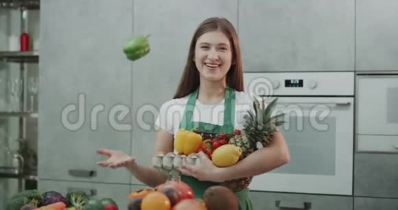 一个在厨房里玩得很开心的女孩向空中扔胡椒视频的预览图