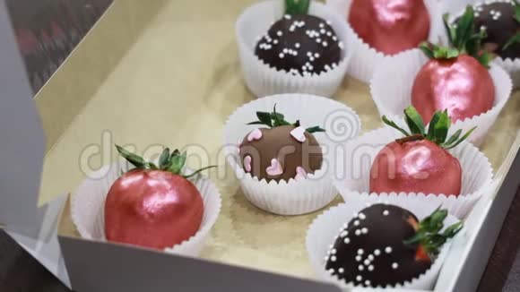 盒子里有手工制作的成熟草莓上面覆盖着深色牛奶和粉红色巧克力缩放运动视频的预览图