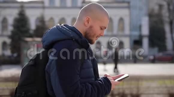 年轻的秃头游客穿过城市视频的预览图