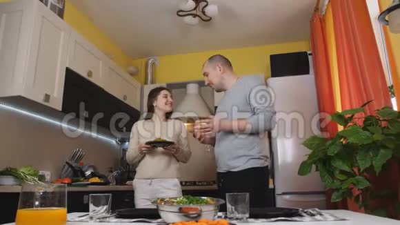 一对年轻夫妇在一起吃饭前摆好桌子视频的预览图