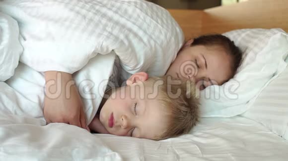 母亲和孩子早上睡在一张白色的床上视频的预览图
