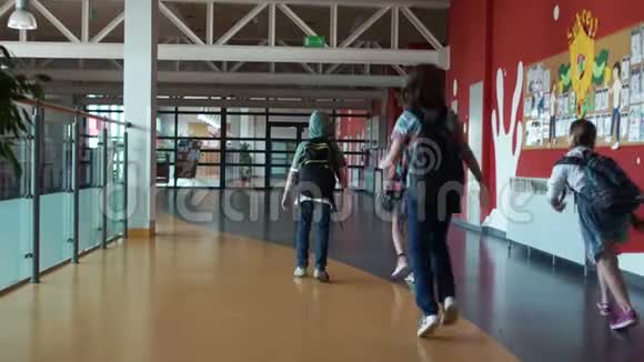 孩子们走在学校大楼的大厅里学校休息一群背着背包的青少年视频的预览图