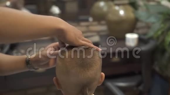 理发师用直剃须刀刮胡子儿童在沙龙理发给理发店的小男孩剃剃头视频的预览图
