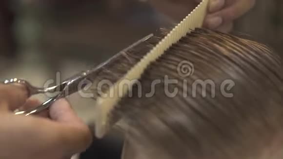 发型师在美发沙龙用理发剪刀剪湿男性头发理发师做男式理发视频的预览图