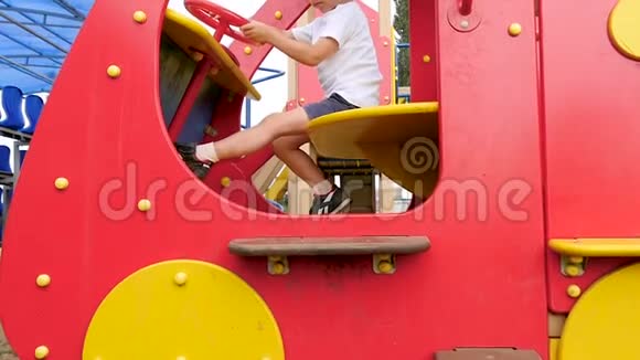 一个孩子在操场上玩红色的车摄像机向上移动视频的预览图