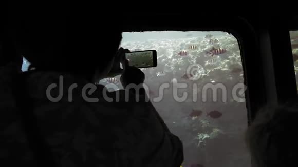 一位资深成年女性游客在移动智能手机上的潜水艇照片上的轮廓无法辨认视频的预览图