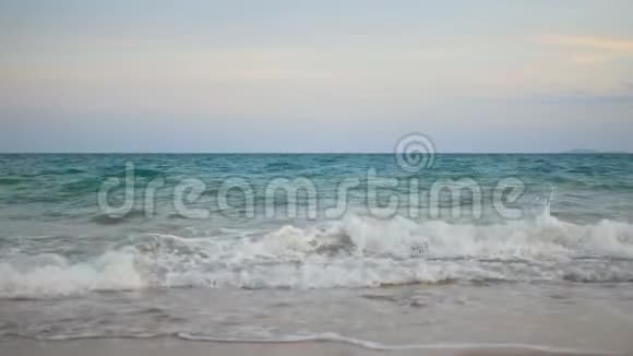 海浪拍打着海滩上的白泡泡傍晚时分暮色降临视频的预览图