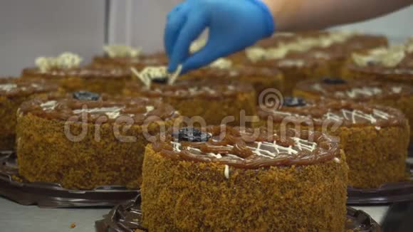 一家糕点厂的糖果店正忙着装饰新鲜美味的蛋糕蛋糕装饰在工作中做蛋糕视频的预览图