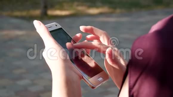 手里拿着一部使用社交网络的智能手机的女孩手指女人触摸触摸屏视频的预览图