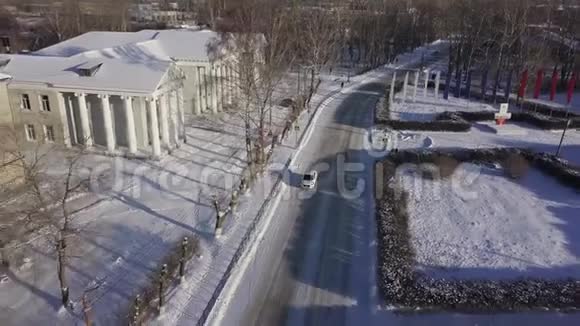 冬季小镇的空中景色有一条雪道和一辆汽车库存录像在美丽中平静的生活视频的预览图