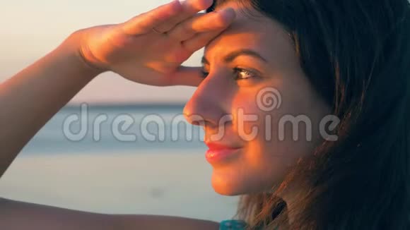 日落时女人用手从太阳中看海视频的预览图