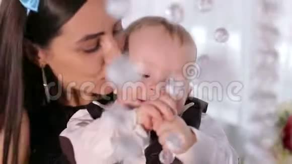 妈妈和一个一岁的儿子在家里玩吊灯上的水晶视频的预览图