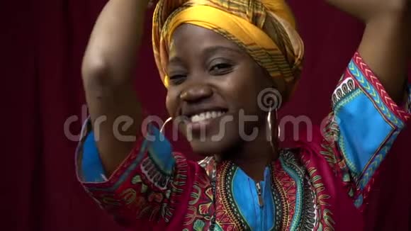 穿着传统服装的黑人非洲女人在演播室里微笑着摆姿势慢动作视频的预览图