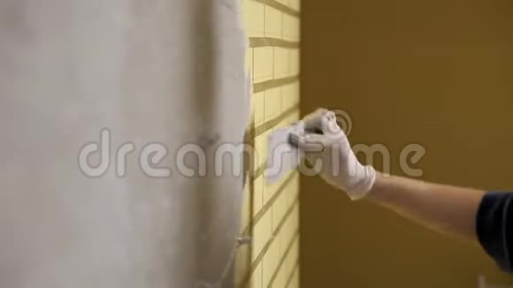 家庭修理女孩用一个大金属抹子把石膏铺在墙上使墙上的石膏填料对齐视频的预览图
