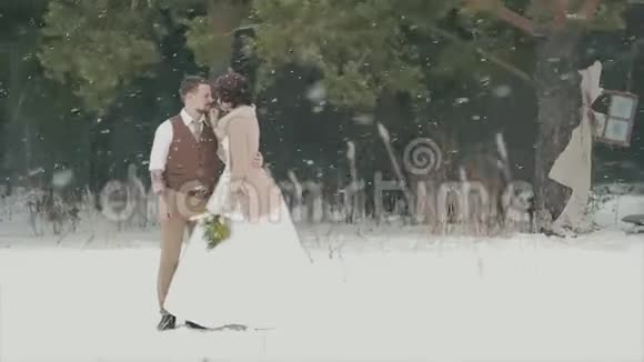 一对爱不释手的情侣站在白雪皑皑的冬季公园里视频的预览图