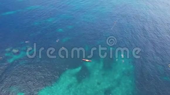一群浮潜者在珊瑚礁上空的浅水中游泳空中景观视频的预览图