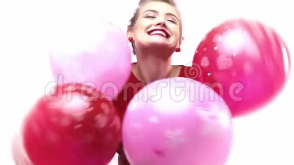 微笑和快乐的年轻女人拿着很多五颜六色的气球慢动作视频的预览图