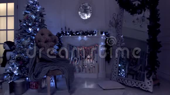 经典的新年和圣诞节背景带有灯灯的夜景在人造壁炉上闪烁的花环和蜡烛视频的预览图