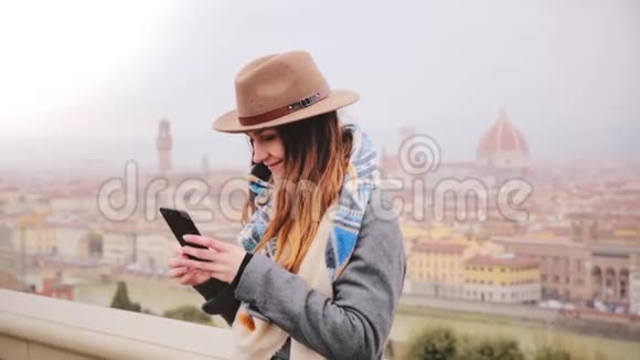 快乐微笑的旅游女孩在惊人的城市景观全景拍摄智能手机自拍照片秋季雾佛罗伦萨意大利视频的预览图