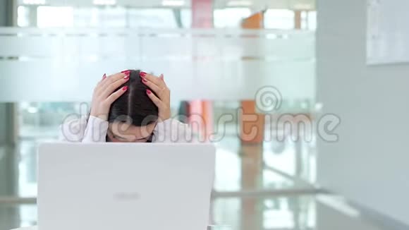 一个年轻的女孩带着笔记本电脑在办公室工作非常沮丧视频的预览图