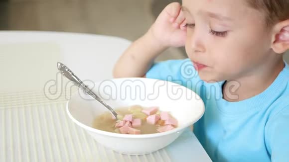 孩子坐在白色的餐桌前吃香肠汤健康宝宝食品的概念视频的预览图