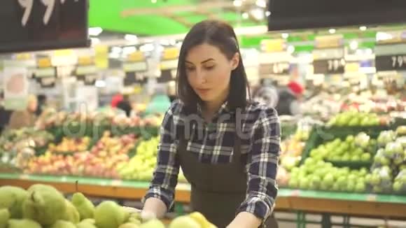 年轻的女店员穿着棕色围裙穿着水果和蔬菜的衣服视频的预览图