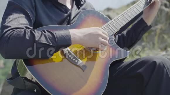 人类的双手在大自然中弹吉他视频的预览图