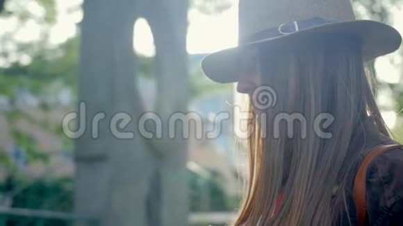 年轻的女人戴着帽子散步享受她的闲暇时间在公园一个夏天近距离射击视频的预览图