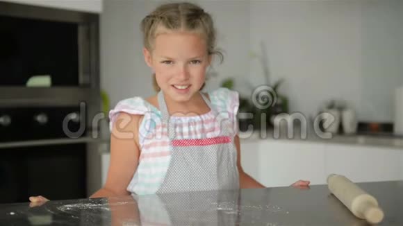 小可爱的女孩在厨房做饭一边做蛋糕和饼干一边玩微笑着看着摄像机视频的预览图