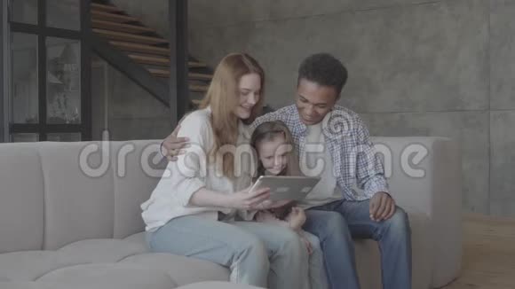 年轻的金发女人白种人和非洲黑人坐在一起他们之间是一个可爱的小女儿国际家庭视频的预览图