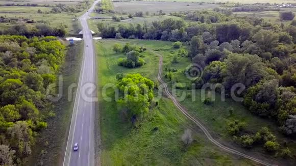 绿色背景下的高速公路俯视图剪辑小径穿过田野背景上的绿树视频的预览图