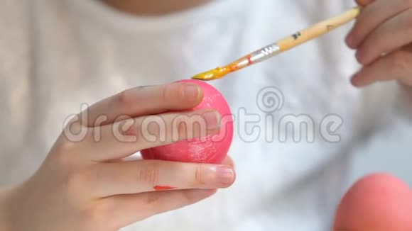 小孩子用黄漆刷装饰染色的复活节彩蛋创造力视频的预览图