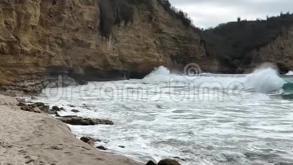 海边的海滩海浪缓慢地撞击着岩石视频的预览图