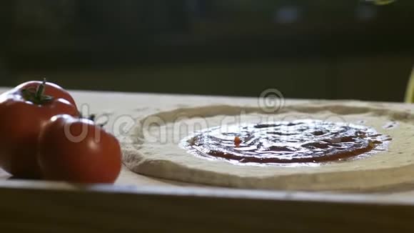 年轻的厨师把去皮番茄铺在比萨饼上视频的预览图