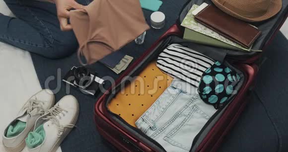 女人手里拿着手提箱在家里的床上旅行旅行准备视频的预览图