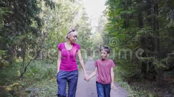 母亲和儿子在公园散步交流未来的教育或职业慢动作视频的预览图